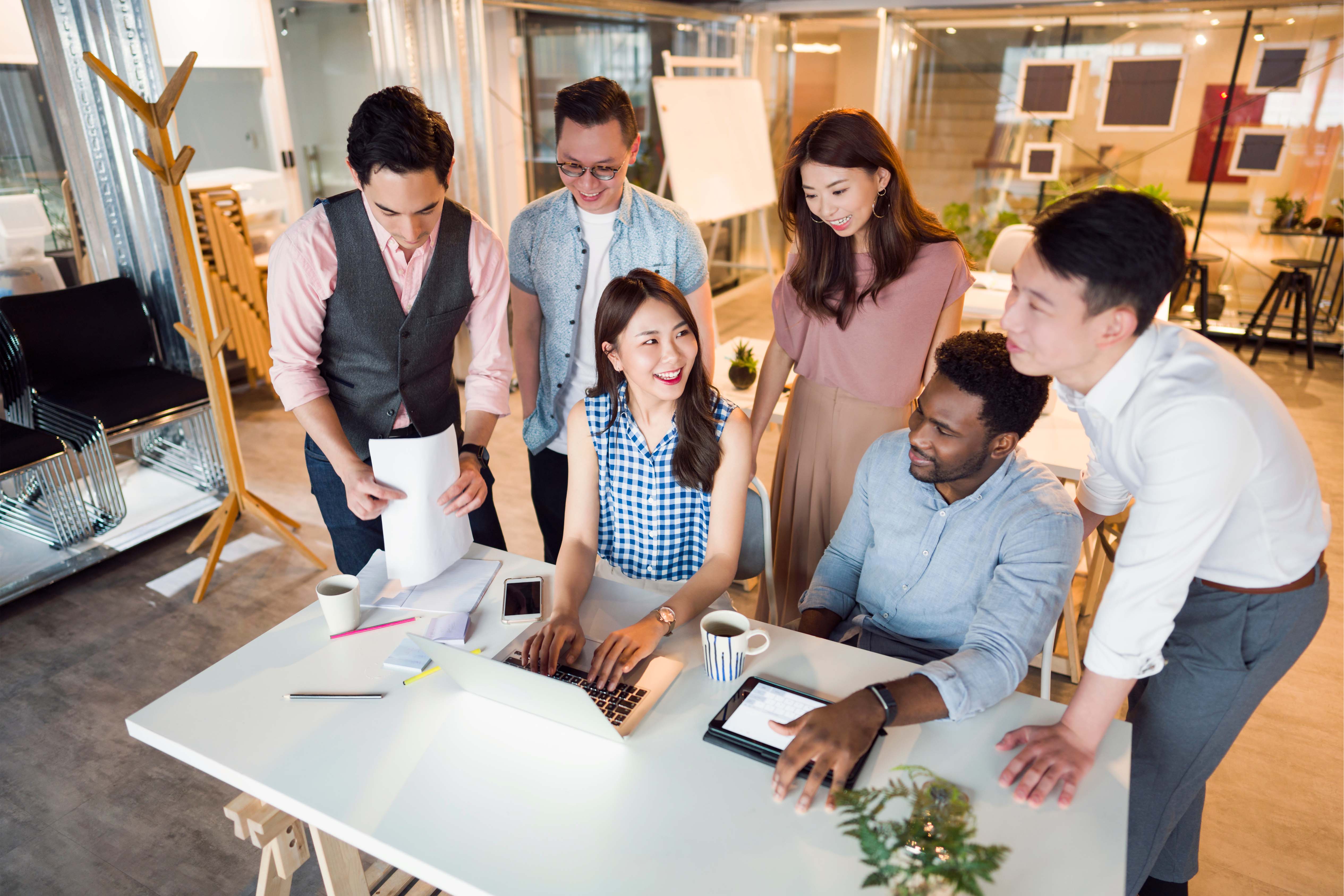 Diverse group of professionals collaborating in a modern open-plan office in Thailand