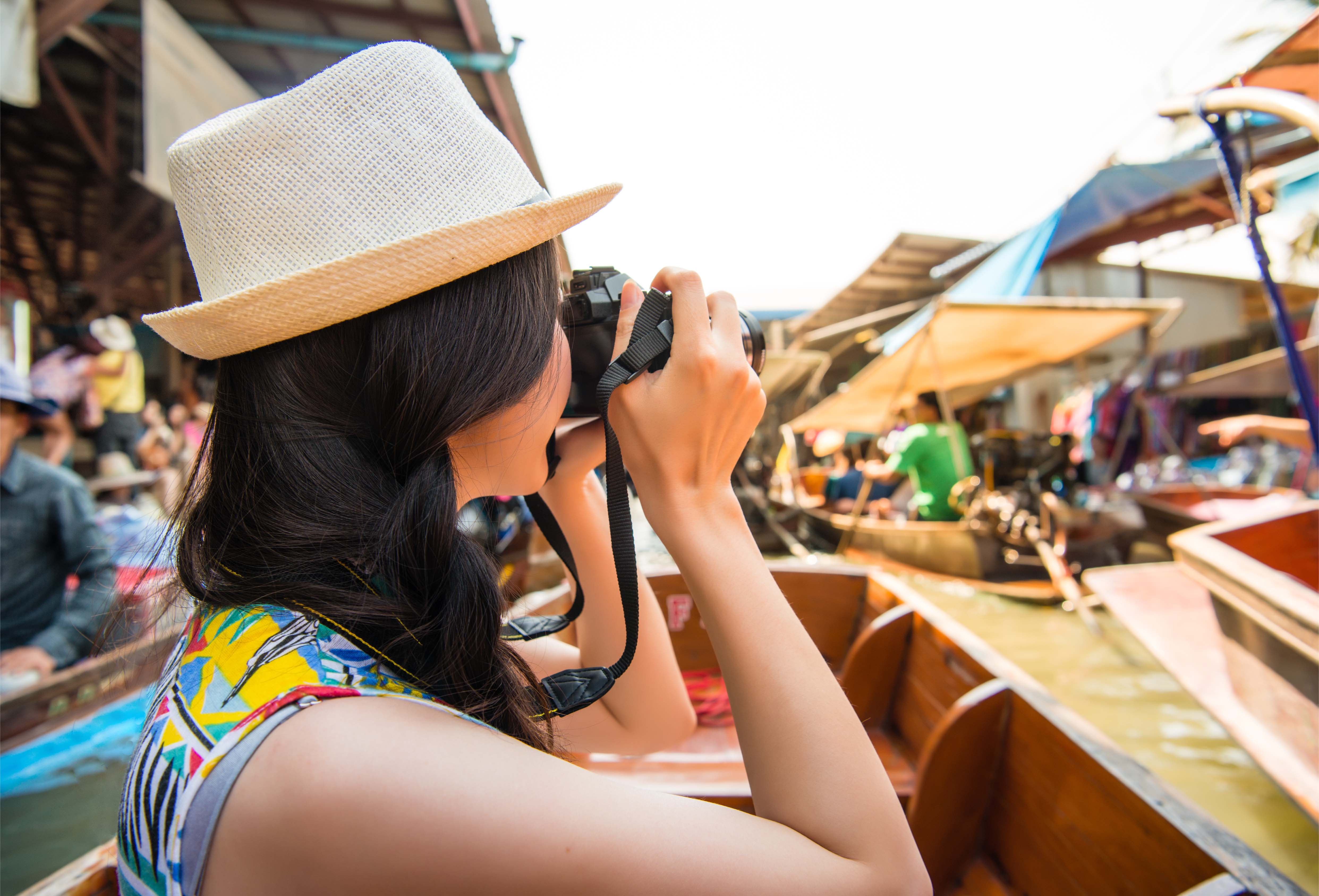Tourist taking photos at a traditional floating market in Thailand