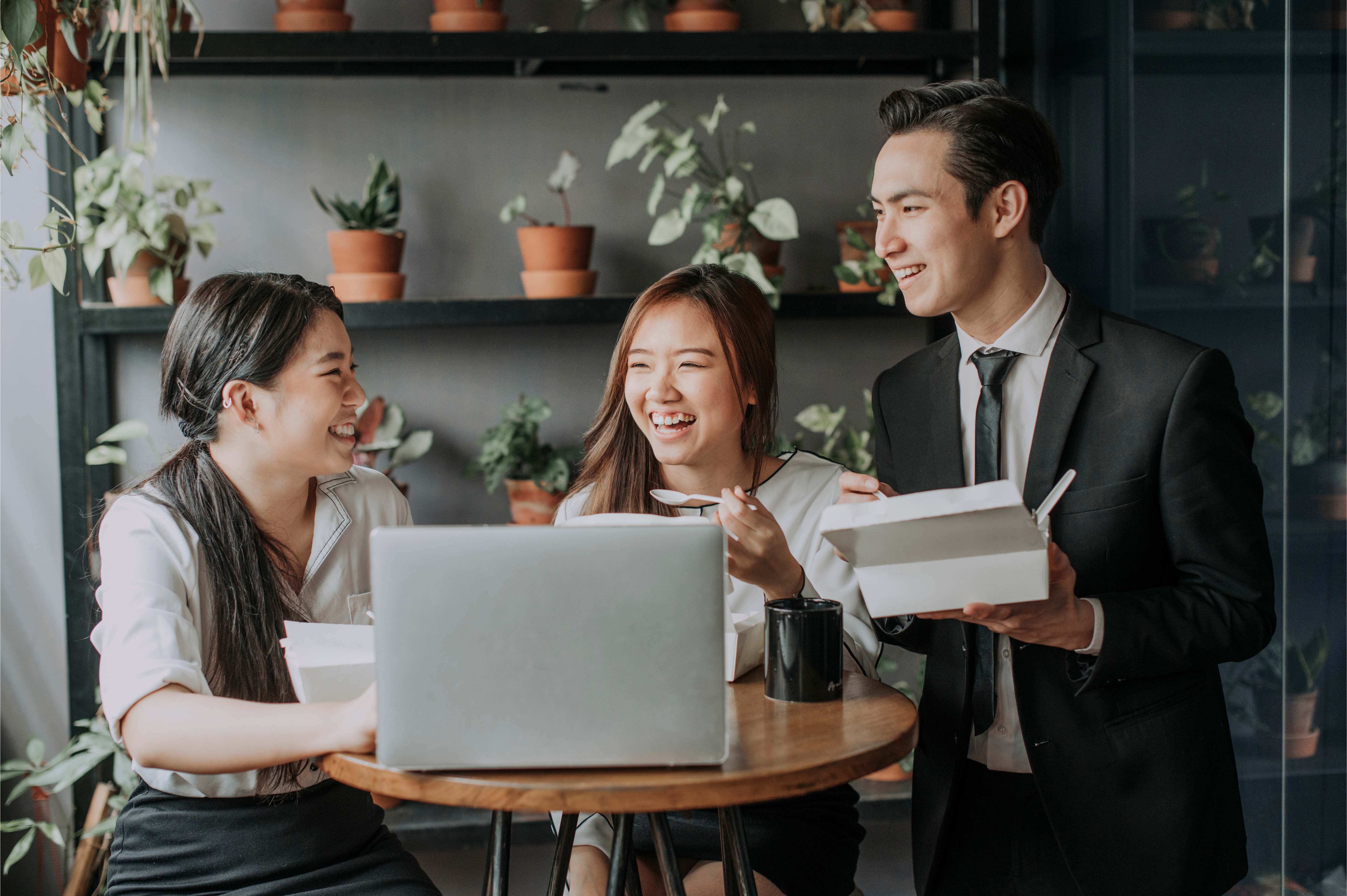 young thai professionals enjoying lunch and laughter during a break at the office