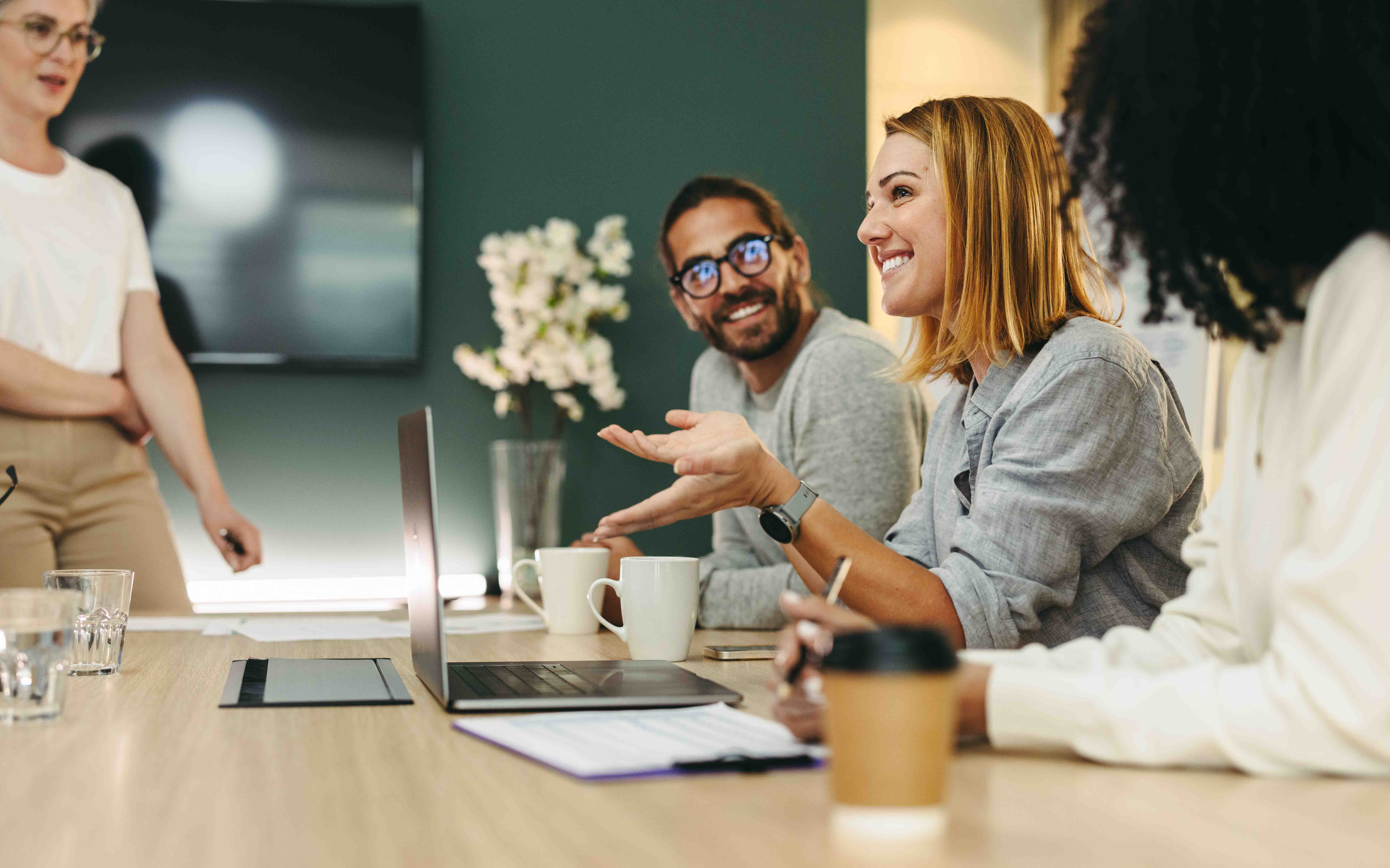 Colleagues sitting at meeting table laughing together