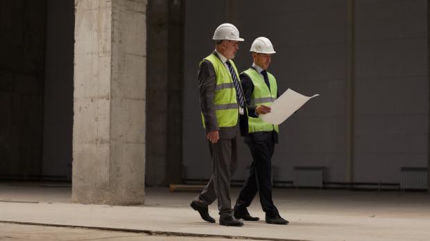 To personer der inspicerer bygning