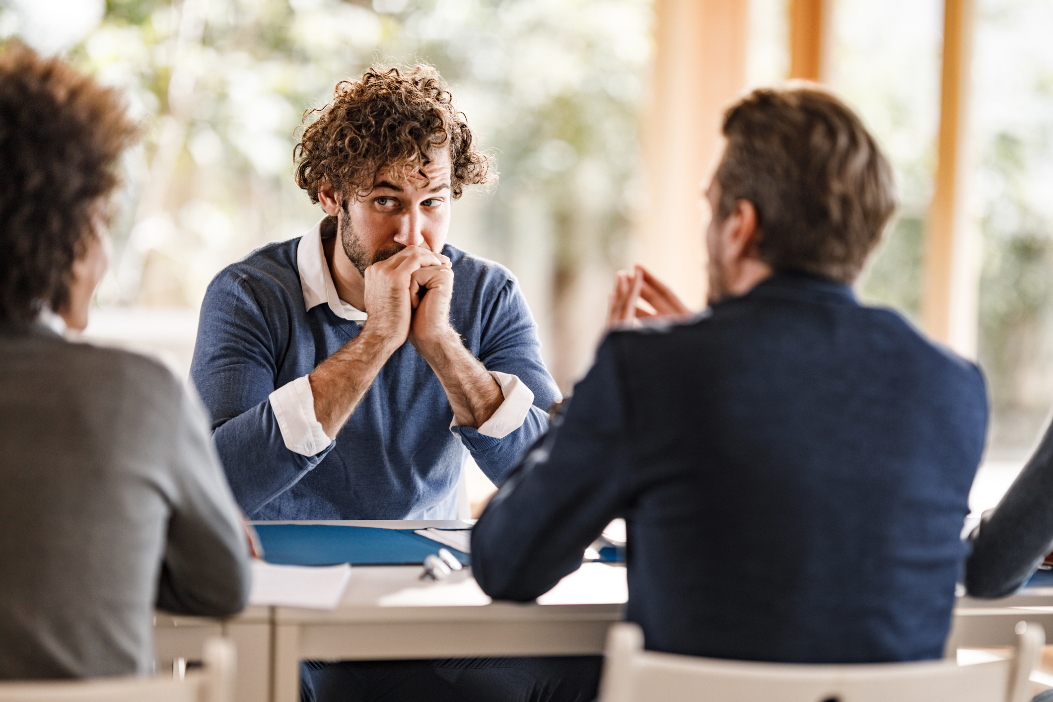 Stressed business director listening to men in suits