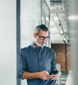 Man standing looking down at his phone