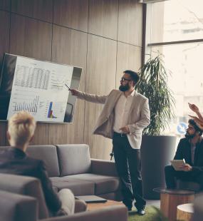 A young professional gives a demonstration to a team of clients