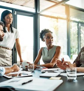 Colleagues talking in office - new mental health guide for recruiters - Howden