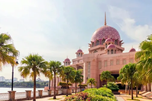 A beautiful mosque with palm trees leading up