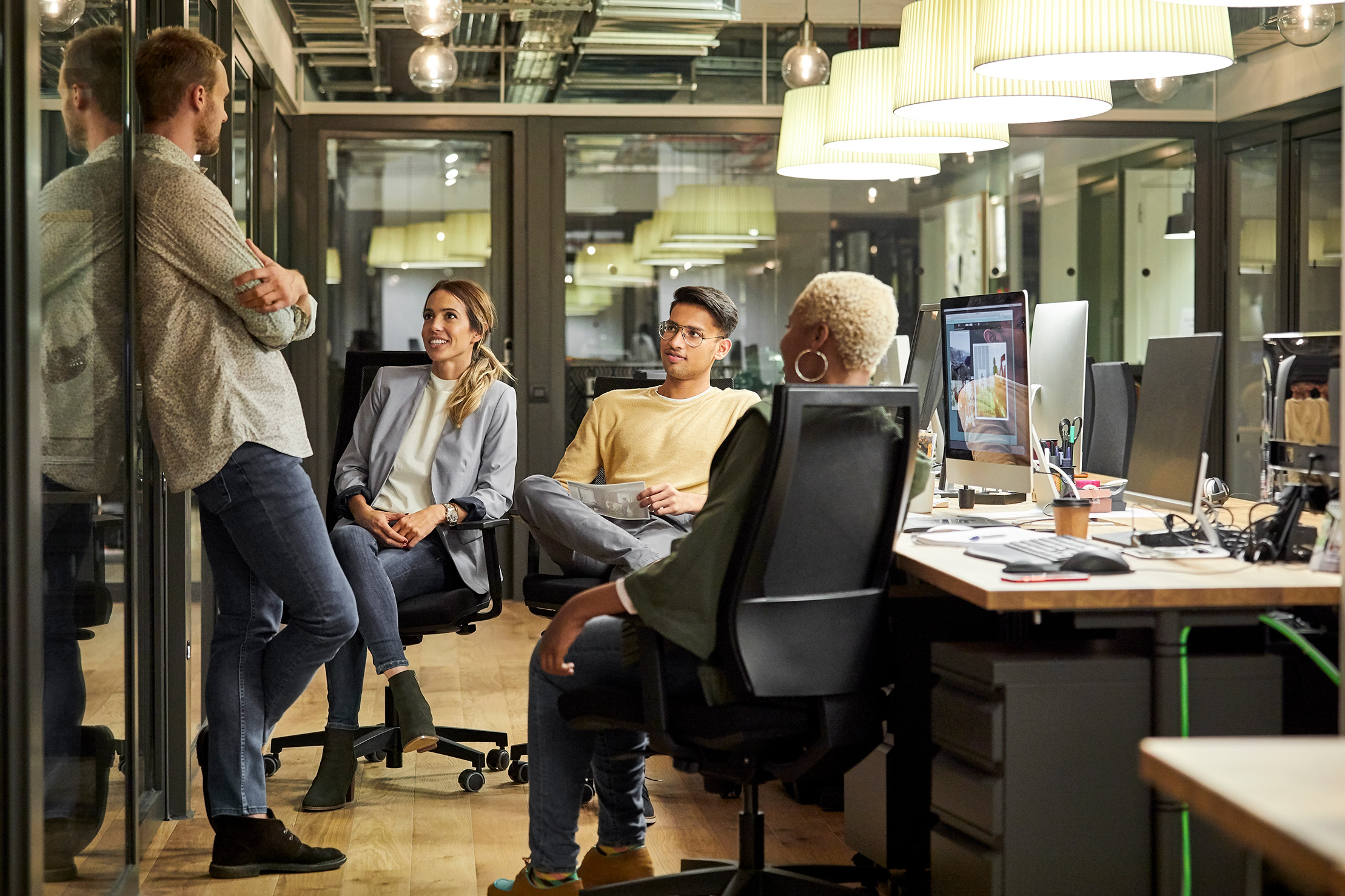 Team sitting and talking at their desks