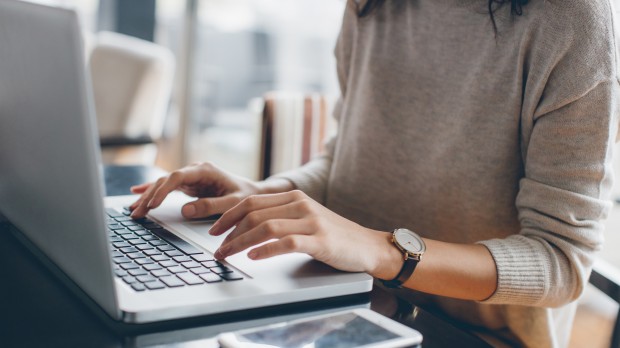 woman sitting as laptop typing on keypad