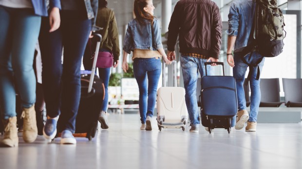 people walking in airport with suitcases