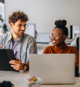 Twee medewerkers achter hun bureau