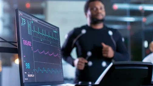 Man on on running machine with EKG data in foreground