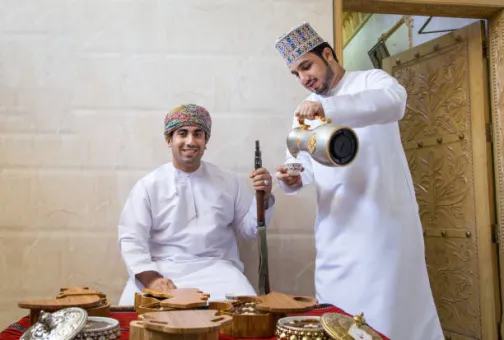 Two Omani men drinking traditional tea
