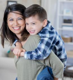 Smiling mother with her son on her back