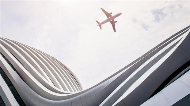 plane flying near modern building plane flying near modern building