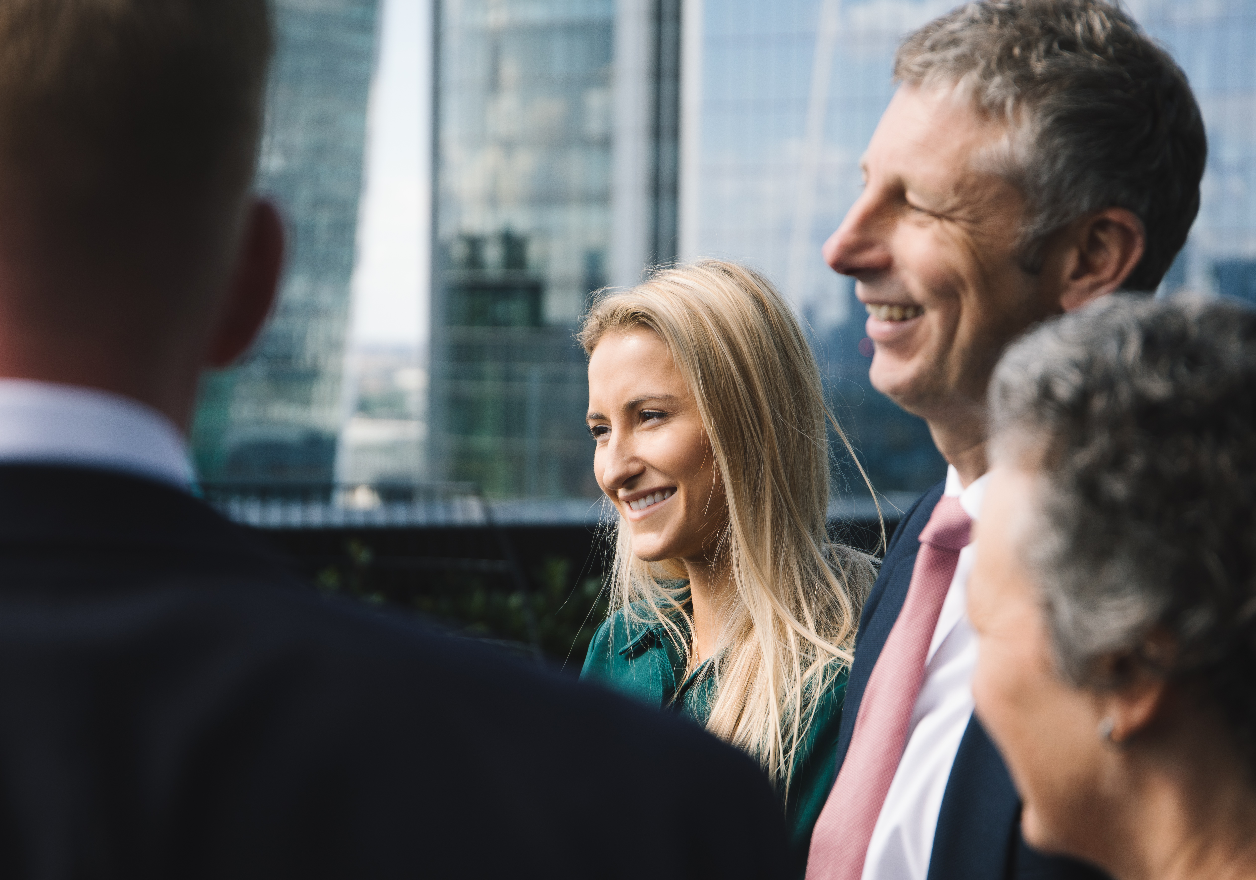 A group of Howden colleagues chat on the balcony of our London office