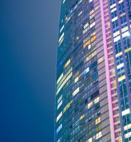 A modern tower block lit up at night