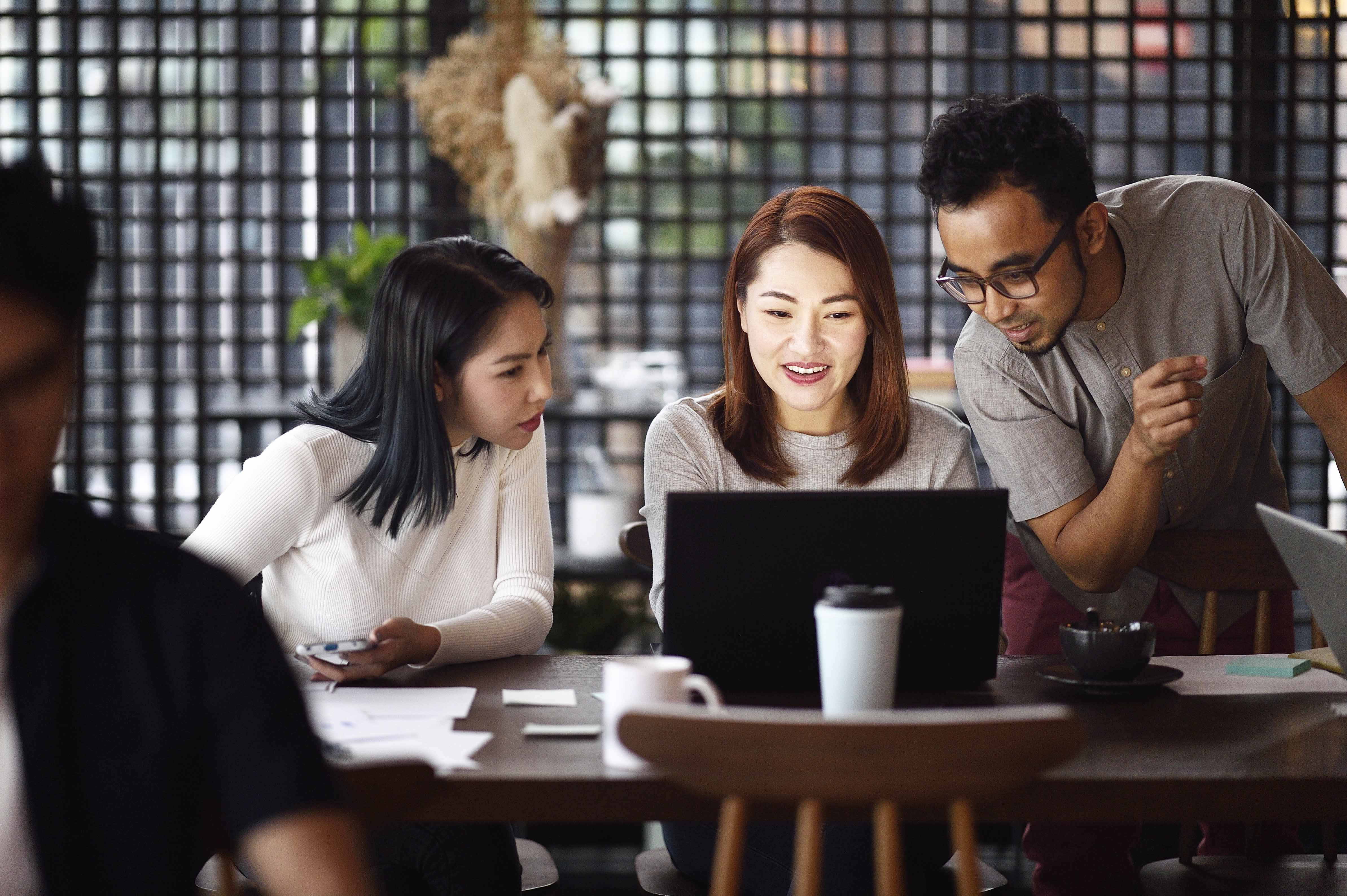 Colleagues looking at laptop screen together