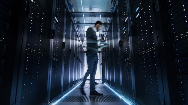 IT engineer examining server racks IT engineer examining server racks
